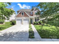 Charming two-story home featuring a two-car garage and inviting curb appeal with well-maintained landscaping at 2210 Winding River Dr, Charlotte, NC 28214