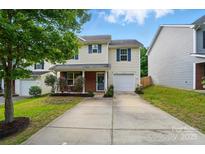 Charming home featuring light yellow siding, brick accents, blue shutters, and a well-maintained front yard at 2234 Dion Ave, Charlotte, NC 28212