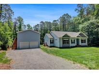 Charming single-Gathering home with a detached two-car garage, lush lawn, and wooded backdrop at 226 Stockwood Ln, Stanley, NC 28164