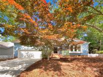 Charming single-story home with blue siding, a two-car garage, and a mature tree in the front yard at 2312 Christensens Ct, Charlotte, NC 28270
