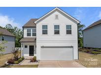 Charming two-story home featuring white siding, an attached garage, and well-maintained landscaping at 3127 Pinehills Way, Mount Holly, NC 28120