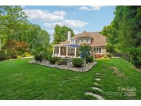 Beautiful backyard featuring a pool, patio, lush landscaping, and a charming stone walkway at 3327 Lakeside Dr, Charlotte, NC 28270