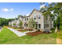 New construction townhomes with lawn, landscaping, sidewalks and neutral siding and brick at 3920 Hager Dr, Charlotte, NC 28208