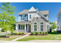 Charming two-story home boasts a stone facade, inviting porch, and well-manicured lawn, perfect for curb appeal at 4051 Whittier Ln, Fort Mill, SC 29708