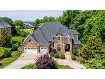 Impressive stone home with a three-car garage, manicured landscaping, and a paver driveway at 4431 1St Street Nw Dr, Hickory, NC 28601
