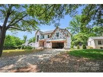 New construction home featuring a two-story design with an attached garage in a wooded location at 4918 Buckingham Dr, Charlotte, NC 28209