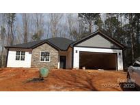 Charming single-story home featuring stone accents, white siding, a dark roof, and an attached two-car garage at 813 Montreat Dr, Dallas, NC 28034