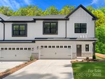 Modern white two-story townhome featuring black framed windows and two-car garage at 8315 Adrian Ct, Charlotte, NC 28270