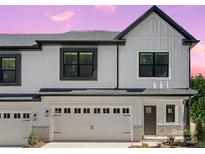 Charming two-story home featuring a two-car garage, craftsman front door and pristine white siding with stone accents at 8315 Adrian Ct, Charlotte, NC 28270