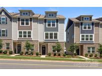 Charming townhome showcasing a well-manicured lawn, brick accents, and neutral siding under a bright sky at 8316 Waxhaw Hwy, Waxhaw, NC 28173