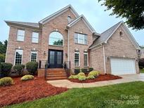 Charming two-story brick home with manicured lawn and black double-door entrance at 8921 Whittingham Dr, Waxhaw, NC 28173