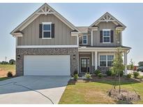 Beautiful two-story home with a white garage door, charming brick accents, and a well-manicured lawn at 102 Cartington Way # Haf0042, Mooresville, NC 28115