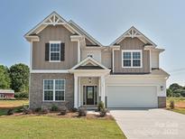 Beautiful two-story home with brick and siding, manicured lawn, and a two-car garage at 113 Tonbridge Way # Haf0031, Mooresville, NC 28115
