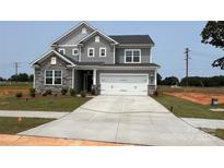 Two-story home featuring a gray color scheme, stone accents, a two-car garage, and a well-manicured front lawn at 119 Tonbridge Way # Haf0033, Mooresville, NC 28115