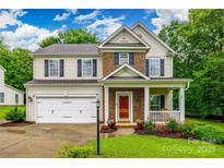 Charming two-story home boasts a well-manicured lawn and inviting front porch with white pillars at 1206 Craig Ave, Lancaster, SC 29720