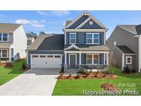 Charming two-story home with blue siding, stone accents, and a well-manicured lawn at 1216 Links Crossing Dr # 159, Monroe, NC 28112