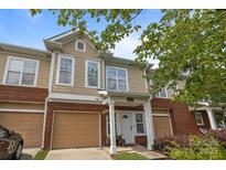Charming townhome with tan siding, brick accents, and an attached single car garage at 15432 Coventry Court Ln, Charlotte, NC 28277