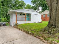 Charming white brick home with a bright turquoise front door and a cozy porch at 1831 Erie St, Charlotte, NC 28216