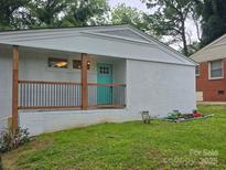 Charming single-story home featuring a teal front door and painted brick exterior at 1831 Erie St, Charlotte, NC 28216