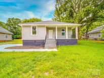 Charming single-story home featuring a covered front porch, gray siding, and a well-maintained lawn at 2440 Myers St, Gastonia, NC 28056