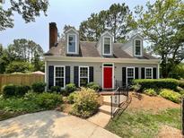 Charming home featuring a red door, black shutters, dormer windows, and beautifully landscaped front yard at 2619 Quailrush Rd, Charlotte, NC 28226