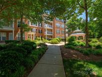 Apartment building exterior with landscaped grounds and a charming gazebo showcasing community amenities and curb appeal at 3248 Margellina Dr, Charlotte, NC 28210