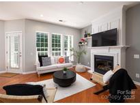 Bright living room featuring a fireplace, large windows, and modern furnishings at 3248 Margellina Dr, Charlotte, NC 28210