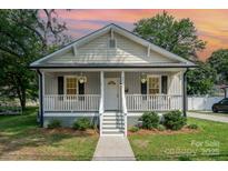 Charming home with a covered front porch, decorative railings, and flower baskets at 330 Central Ave, Kannapolis, NC 28081