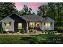 Charming home with a combination of modern black and white facade with professionally landscaped front yard at 402 Wildlife Rd, Troutman, NC 28166
