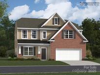 Charming two-story home featuring a brick and siding facade with a two-car garage and well-manicured lawn at 4247 Skyboat Cir, Fort Mill, SC 29715