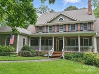 Charming two-story brick home featuring a welcoming front porch, manicured lawn, and a classic American aesthetic at 550 Burrage Ne Rd, Concord, NC 28025