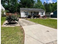 Charming single-story home with a well-maintained lawn and a paved driveway at 6000 Amberly Ln, Charlotte, NC 28213