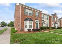 Charming brick townhome with a manicured lawn and green shutters on a sunny day at 6309 Margaret Ct, Indian Trail, NC 28079