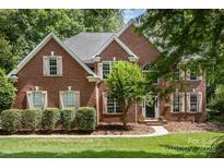 Charming two-story brick home with manicured landscaping, shutters, and a welcoming front entrance at 6419 Antioch Ct, Matthews, NC 28104