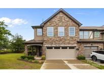 Charming townhome with stone facade, attached garage, and well-manicured lawn at 809 Ayrshire Ave, Fort Mill, SC 29708