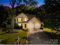Charming two-story home with a well-maintained lawn, mature trees, and an inviting entrance at 10908 Delsing Ct, Charlotte, NC 28214