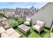 Inviting roof deck featuring comfortable seating, artificial turf, and a stunning view of the city skyline at 11043 Stetler St, Charlotte, NC 28204
