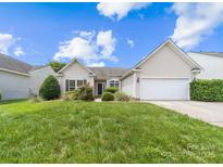 Charming single-story home featuring a well-manicured lawn and attached two-car garage on a sunny day at 1107 Rachel Anne Dr, Belmont, NC 28012