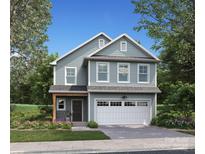 Charming two-story home featuring a light blue facade, white garage door, and a meticulously landscaped front yard at 1133 Thayer Glen Ct, Charlotte, NC 28213