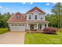Charming two-story home featuring a landscaped yard, two-car garage and welcoming front porch at 1155 Rudder Cir, Salisbury, NC 28146