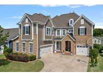 Beautiful two-story home featuring stone accents, neutral siding, a two-car garage, and a well-manicured lawn at 12214 Bonny Oaks Dr, Cornelius, NC 28031