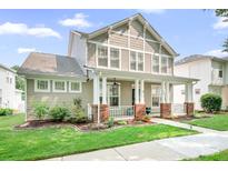 Charming two-story home featuring a welcoming front porch, lush landscaping, and classic architectural details at 14923 Almondell Dr, Huntersville, NC 28078