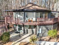 Unique home featuring a wrap-around deck, modern design, and wooded surroundings at 2143 Manawa Ln, Tega Cay, SC 29708