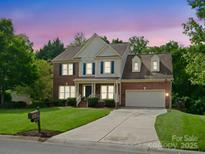 Charming two-story brick home featuring a manicured lawn and attached two-car garage at 2821 Providence Spring Ln, Charlotte, NC 28270