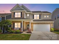 Charming brick and siding home with a two-car garage and manicured lawn at 3471 Melwood Estates Dr, Denver, NC 28037