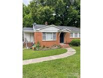 Charming single-story brick home with a walkway to the front door and green lawn at 507 N Secrest Ave, Monroe, NC 28110