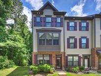 Charming townhome featuring detailed brickwork, a bay window, and neat landscaping at 513 Cubitt Ct, Charlotte, NC 28205
