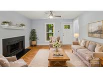 Bright living room features a cozy fireplace, hardwood floors, and ample natural light at 5414 Leaford Ct, Charlotte, NC 28227