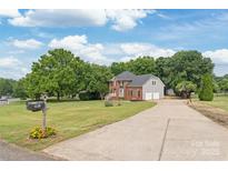 Inviting two-story brick home with an attached two car garage and long driveway at 9004 Lauriston Pl, Mint Hill, NC 28227
