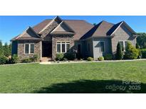 Beautiful exterior home showing stone and vinyl siding, manicured lawn, and inviting front entrance at 9125 Dylan Ridge Ct, Concord, NC 28027